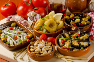 Spanish cuisine. Assortment of  Tapas including Serrano Ham,  Marinated Olives, Mussels in Sauce and others, served with red wine.